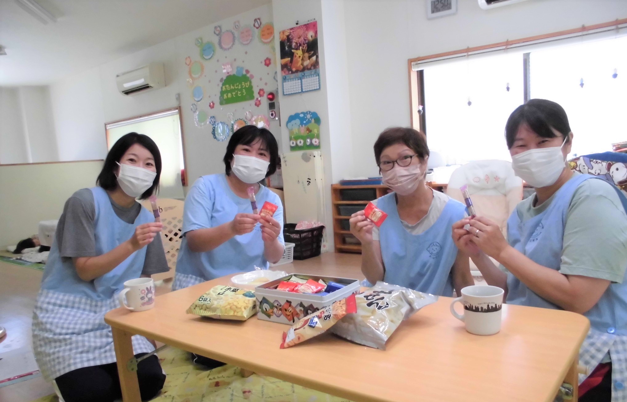 <SUKUERUで届いたおかしを楽しむ保育士の様子>